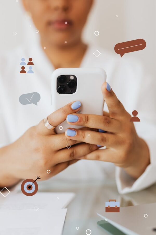 Close-up of person holding smartphone surrounded by digital icons.